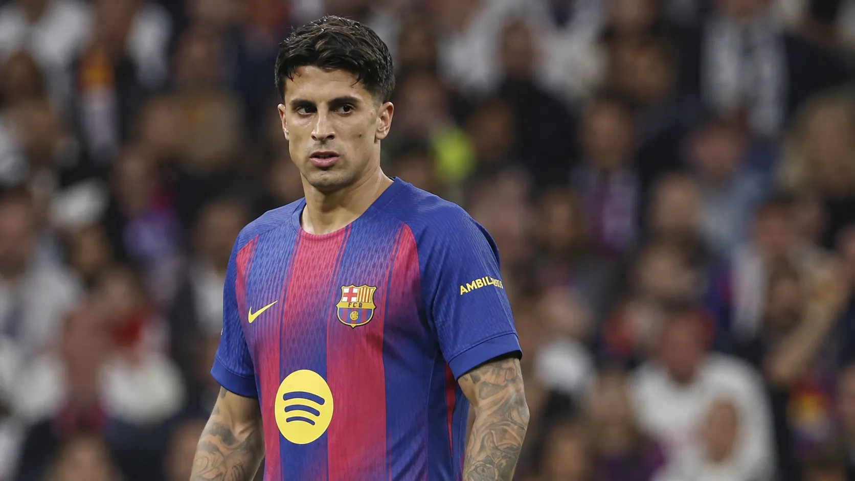 Een Barcelona-speler in blauw-rood wedstrijdshirt kijkt geconcentreerd tijdens een wedstrijd in het stadion.