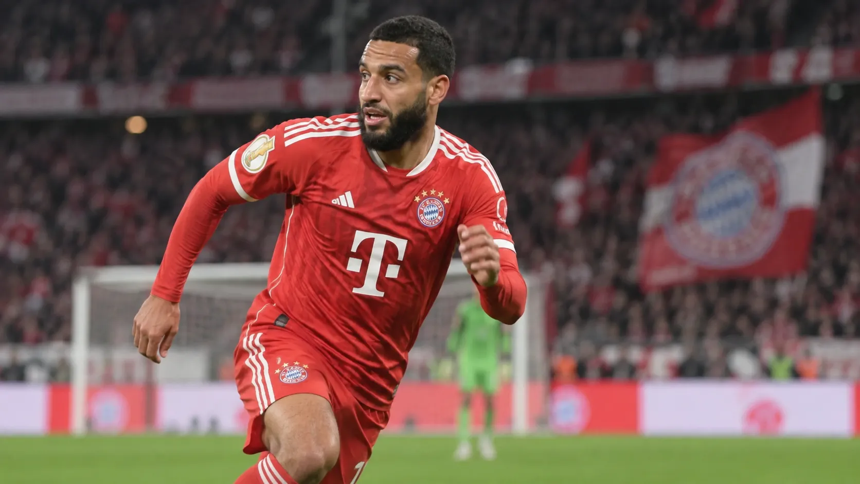 Een Bayern München-speler in rood tenue tijdens een bekerwedstrijd in een vol stadion.