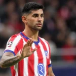 Cristian Romero in een rood-wit gestreept voetbalshirt aan de rand van het veld.
