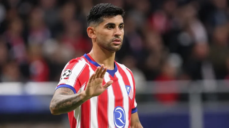 Cristian Romero in een rood-wit gestreept voetbalshirt aan de rand van het veld.