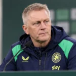 Heimir Hallgrimsson zit tijdens een persconferentie aan een tafel in een neutrale perszaal.