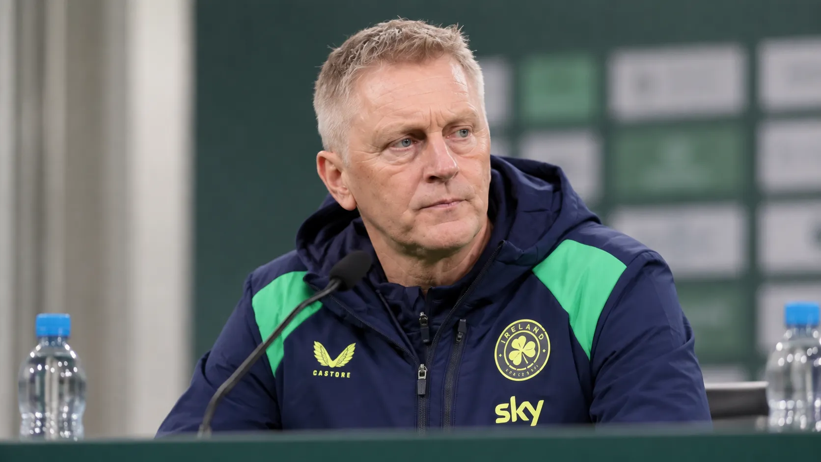 Heimir Hallgrimsson zit tijdens een persconferentie aan een tafel in een neutrale perszaal.