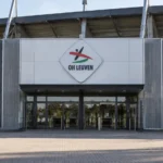 De lege ingang van een voetbalstadion met een geïntegreerd OH Leuven-clubembleem.