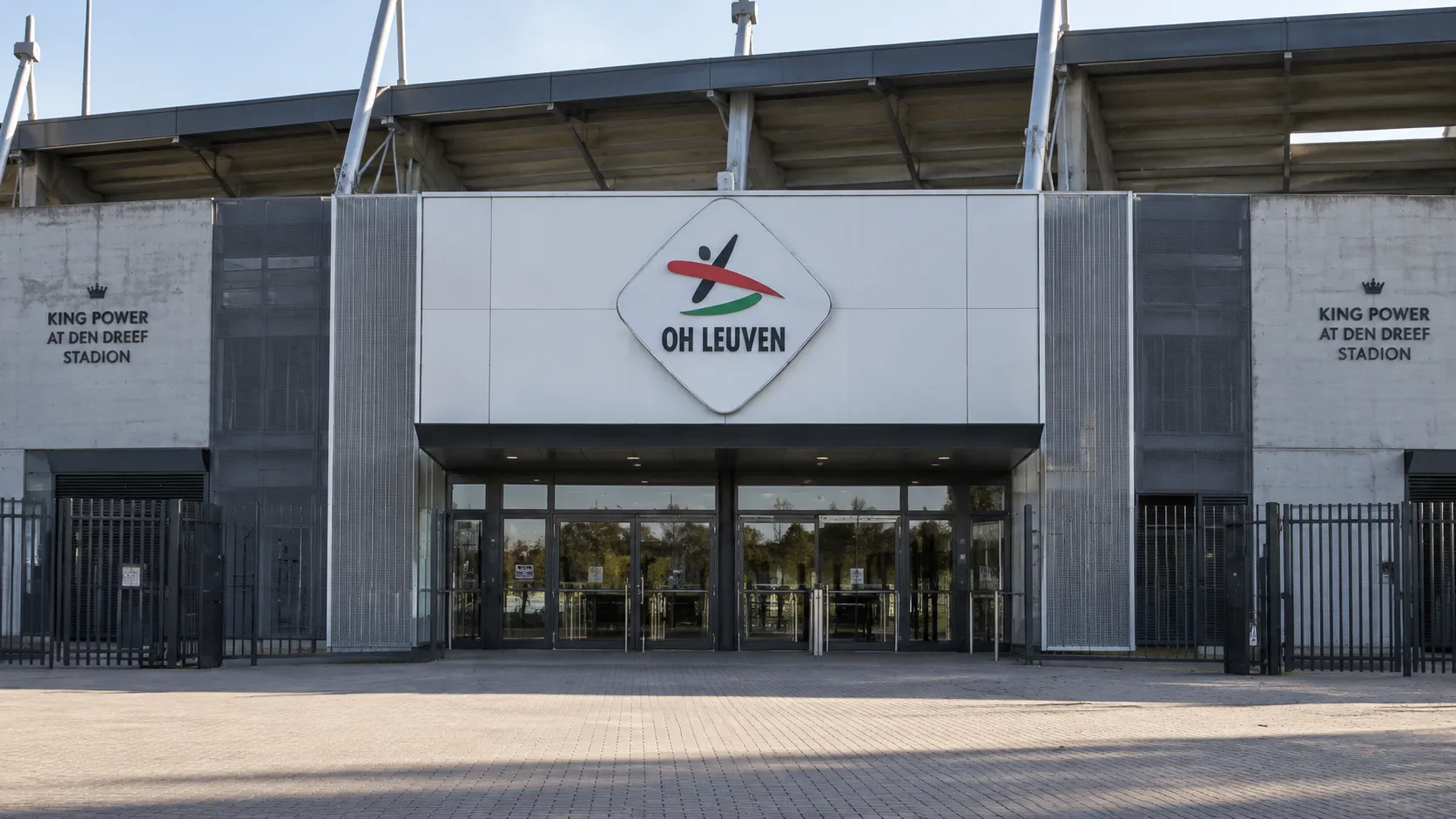 De lege ingang van een voetbalstadion met een geïntegreerd OH Leuven-clubembleem.