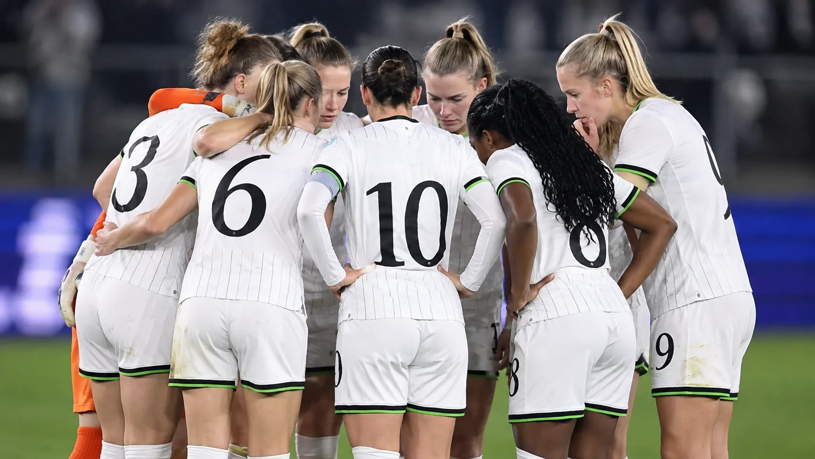 Speelsters van OH Leuven verzamelen in een hechte kring op het veld.