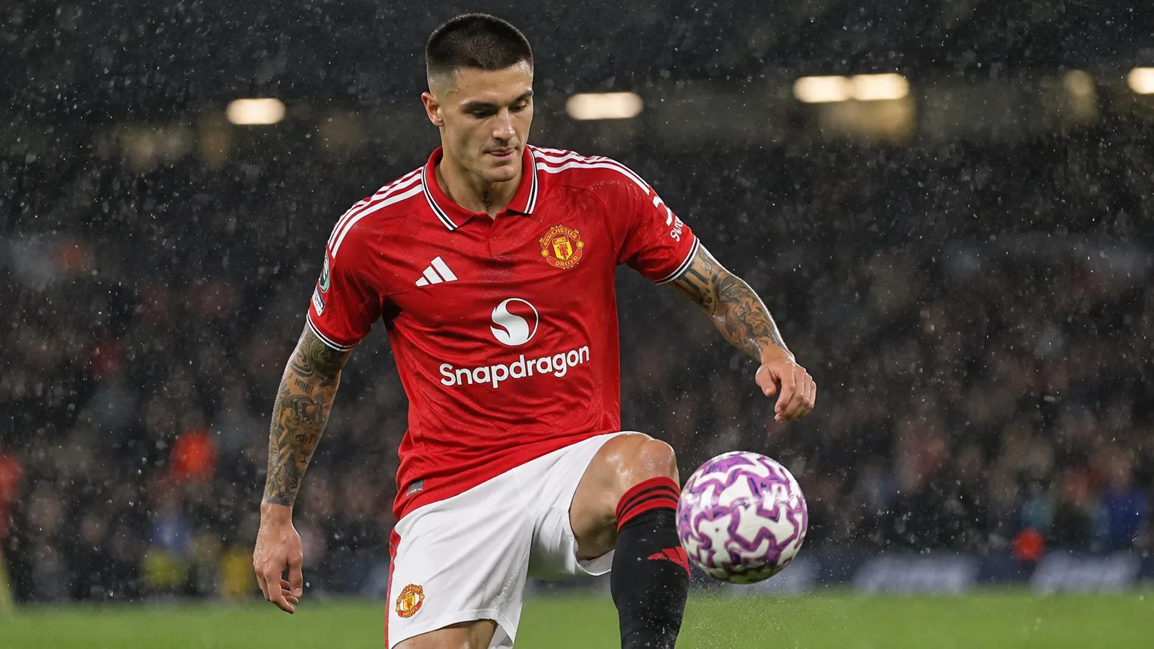 Benjamin Sesko in een rood clubtenue tijdens een voetbalwedstrijd in de regen.