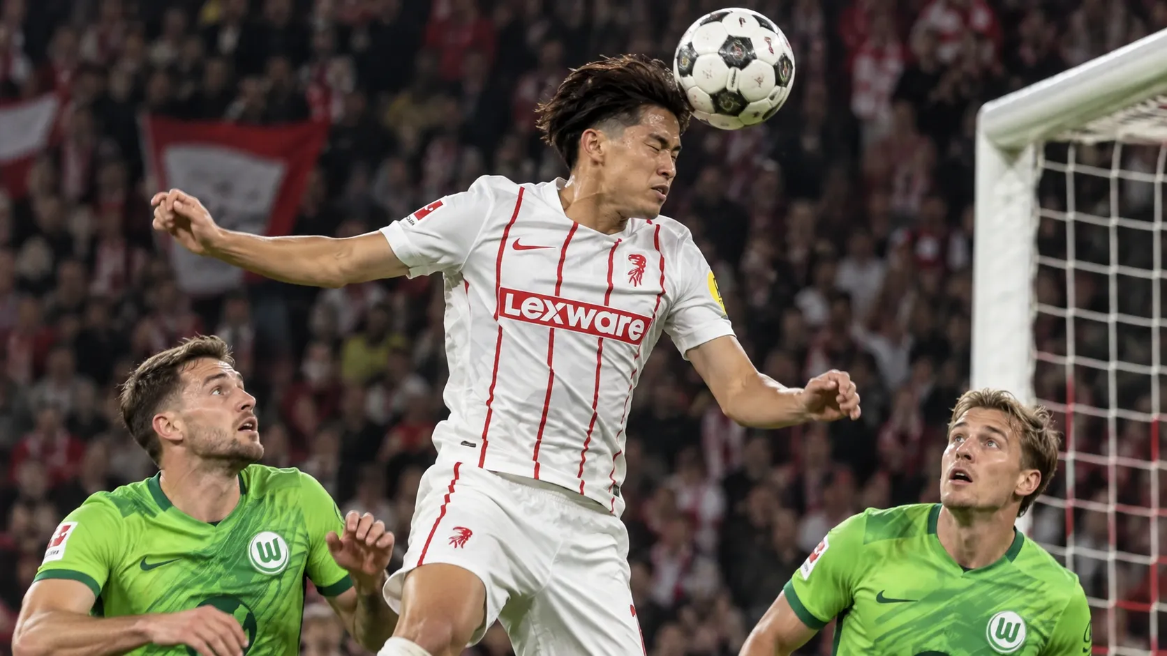 Keisuke Goto van SC Freiburg kopt een hoekschop tijdens een bekerwedstrijd.