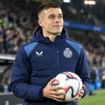 Nicolo Tresoldi in een Club Brugge-jas langs de rand van het veld.