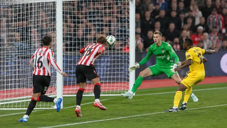 Spelers in actie voor doel met een doelman in groen tijdens een League Cup-wedstrijd.