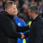 Twee coaches geven elkaar na afloop de hand op de zijlijn.