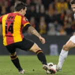 Een speler van KV Mechelen in rood-geel tijdens een wedstrijdactie.