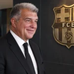 Een clubfunctionaris in donker kostuum in een institutionele ruimte van FC Barcelona.