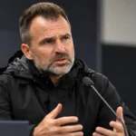 Ivan Leko spreekt geconcentreerd tijdens een persmoment in een sobere persruimte.