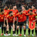 Belgische nationale ploeg verzamelt in rode tenues voor een groepsfoto in het stadion.