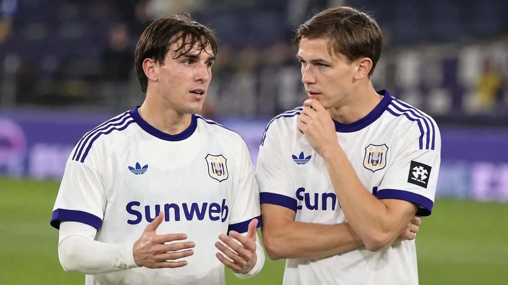 Twee Anderlecht-spelers overleggen naast elkaar tijdens een opwarming.