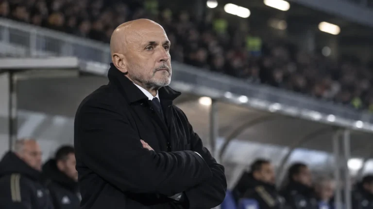 Een Juventus-trainer in donkere jas aan de rand van het veld.