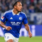 Anton Donkor in het blauwe tenue van Schalke 04 op een voetbalveld.