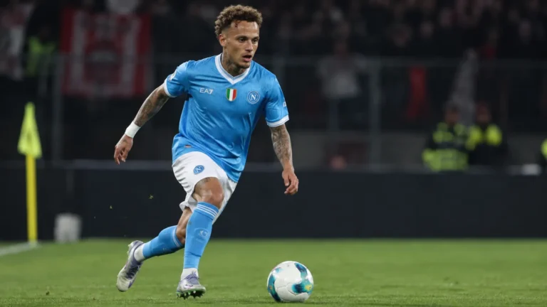 Noa Lang dribbelt in het lichtblauwe shirt van Napoli tijdens een avondwedstrijd.