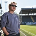 Rik Verheye staat langs een voetbalveld in afwachting van de wedstrijd van Sporting Hasselt.