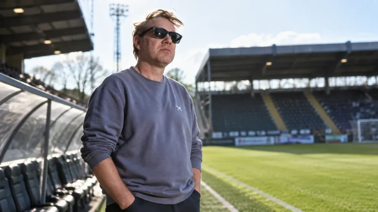 Rik Verheye staat langs een voetbalveld in afwachting van de wedstrijd van Sporting Hasselt.
