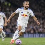 Leeds United-spelers tijdens een avondwedstrijd in een vol stadion.