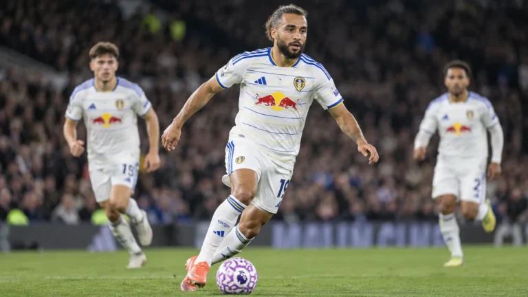 Leeds United-spelers tijdens een avondwedstrijd in een vol stadion.