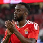 Dodi Lukebakio applaudisseert in het rode tenue van Benfica op het veld.