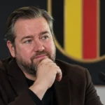 Een bondsmedewerker in donker jasje in een ruimte van de Belgische voetbalbond.
