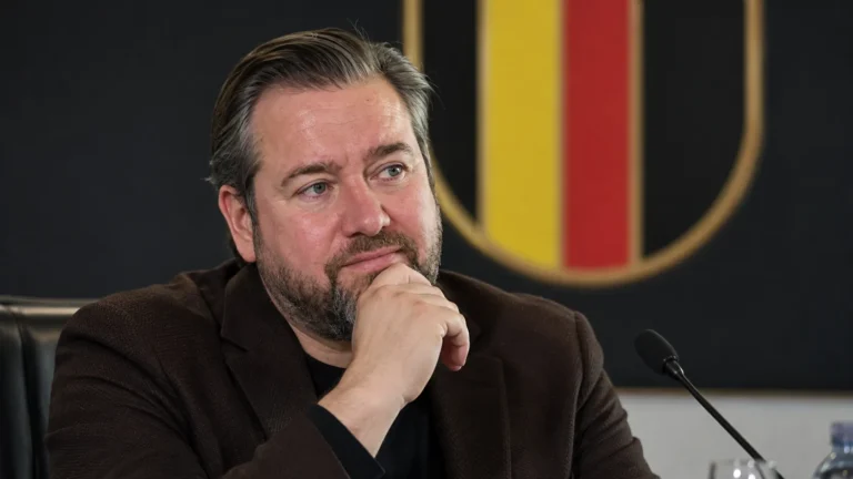 Een bondsmedewerker in donker jasje in een ruimte van de Belgische voetbalbond.