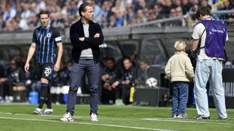 Ruud Vormer op een voetbalveld met een Club Brugge-speler en clubmedia op de achtergrond.
