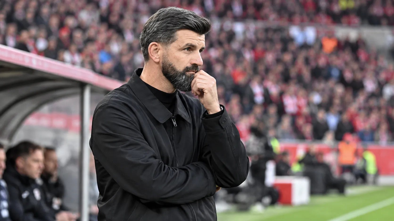 Miron Muslic staat geconcentreerd langs de zijlijn van een voetbalstadion.