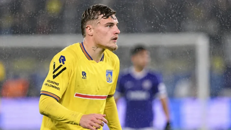 Norman Bassette van KVC Westerlo op een regenachtig voetbalveld.