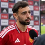 Bruno Fernandes in het rode tenue van Manchester United terwijl hij vragen beantwoordt.