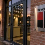 De ingang van een RWDM-clubadministratie met een vast metalen clubembleem aan de gevel.