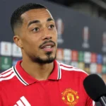Youri Tielemans spreekt in het rood van Manchester United in een mixed zone.