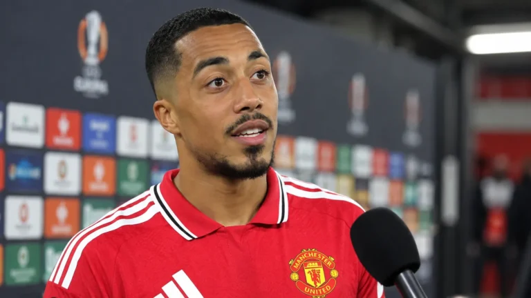 Youri Tielemans spreekt in het rood van Manchester United in een mixed zone.