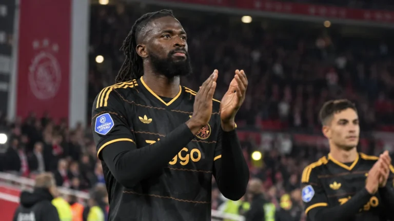 Tolu Arokodare applaudisseert in een donker Ajax-shirt in het stadion.