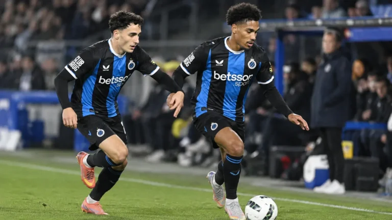 Twee voetballers in blauw-zwarte shirts in een nieuw wedstrijdmoment.