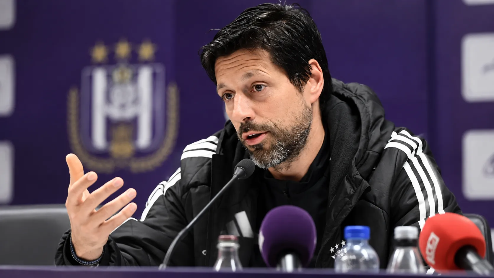 Vitor Bruno spreekt met opgeheven handen tijdens een persconferentie van Anderlecht.
