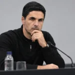 Mikel Arteta spreekt op een persconferentie in neutrale zwarte kleding.