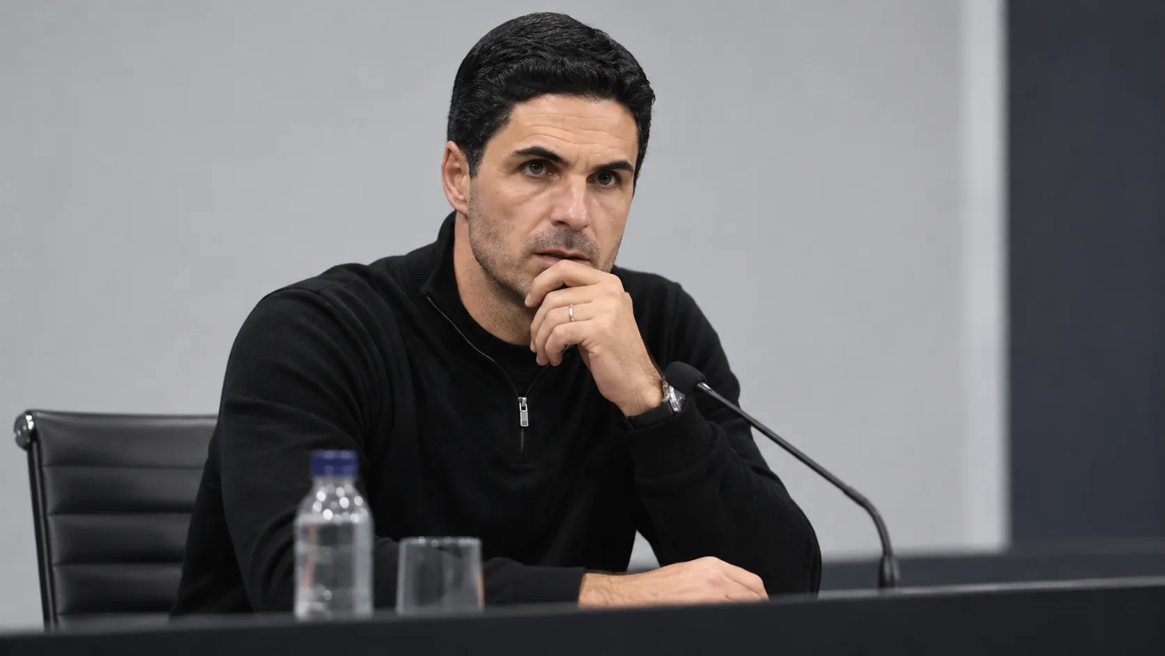 Mikel Arteta spreekt op een persconferentie in neutrale zwarte kleding.