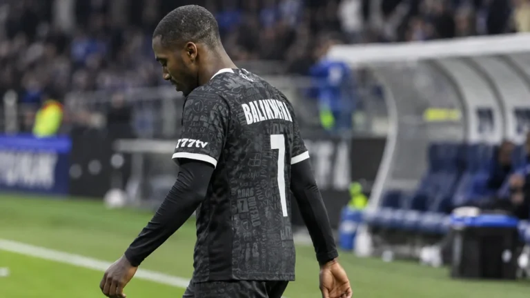 Michel-Ange Balikwisha van KAA Gent wandelt langs de zijlijn in wedstrijdtenue.
