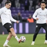 Twee Anderlecht-spelers warmen op met een bal op het veld.