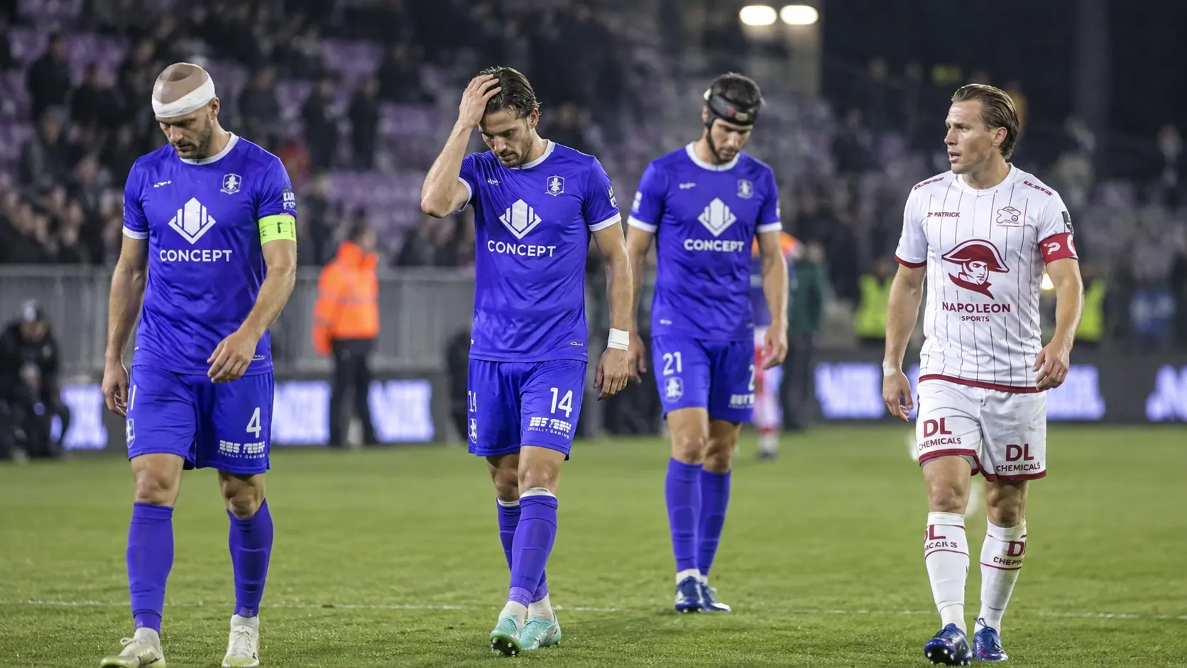 Spelers in paarse en witte tenues verlaten na een wedstrijd het veld.