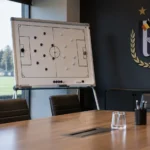 Lege tactische vergaderruimte van RSC Anderlecht met een clubembleem aan de wand.