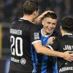 Een groep spelers van Club Brugge viert samen op het veld tijdens een wedstrijd.