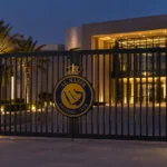 Onbemande ingang van een Al-Nassr-clubgebouw met het clubembleem op de poort.