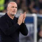 Philippe Clement applaudisseert langs de zijlijn in donkere coachkleding.