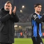 Een Club Brugge-trainer en speler applaudisseren na een wedstrijd in het stadion.