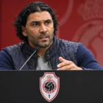 Marvin Compper spreekt op een persconferentie achter een lessenaar met het Antwerp-embleem.